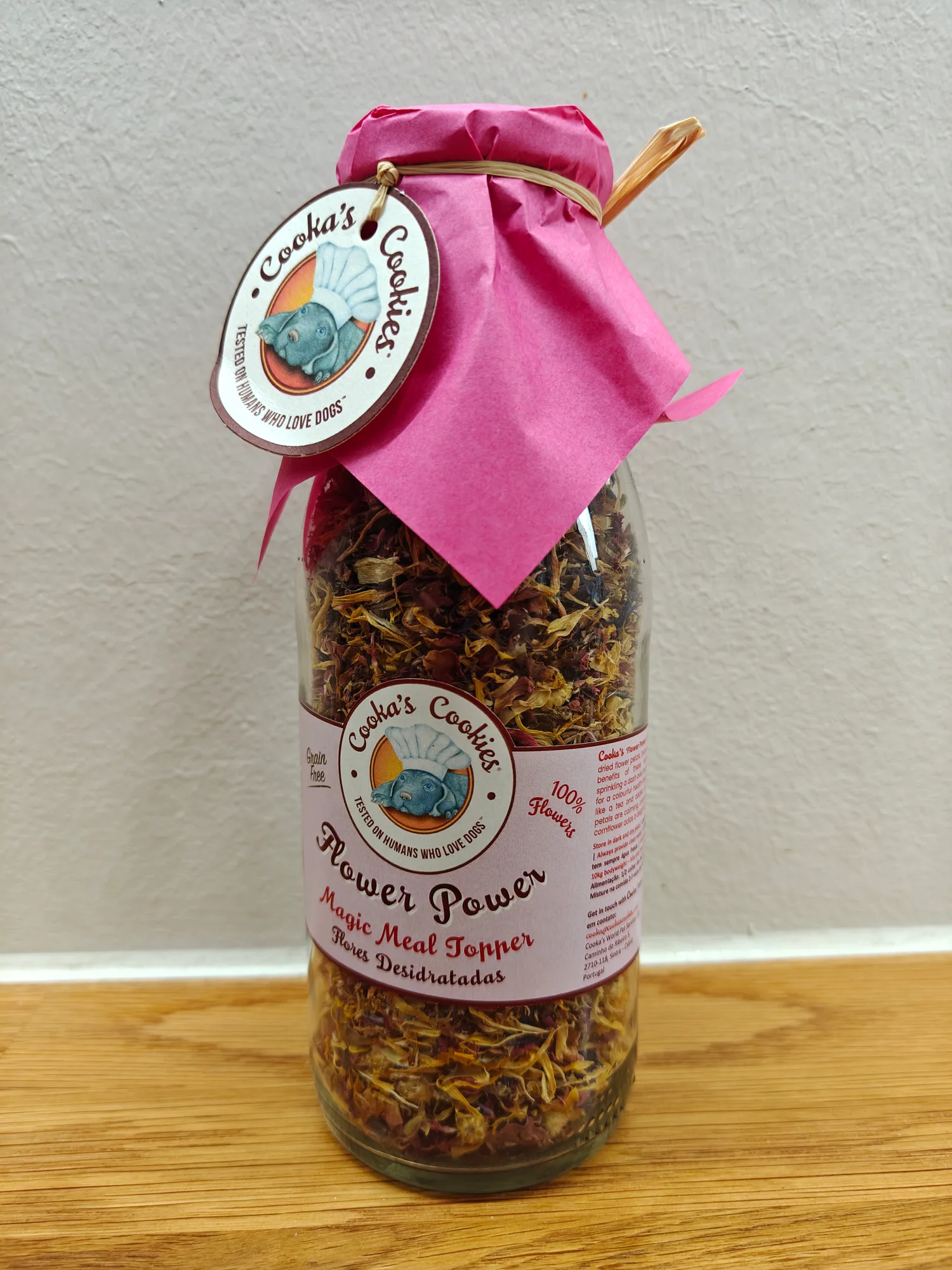 Flower-power — lukket glasflaske med pink indpakningspapir og Cooka's Cookies-mærke